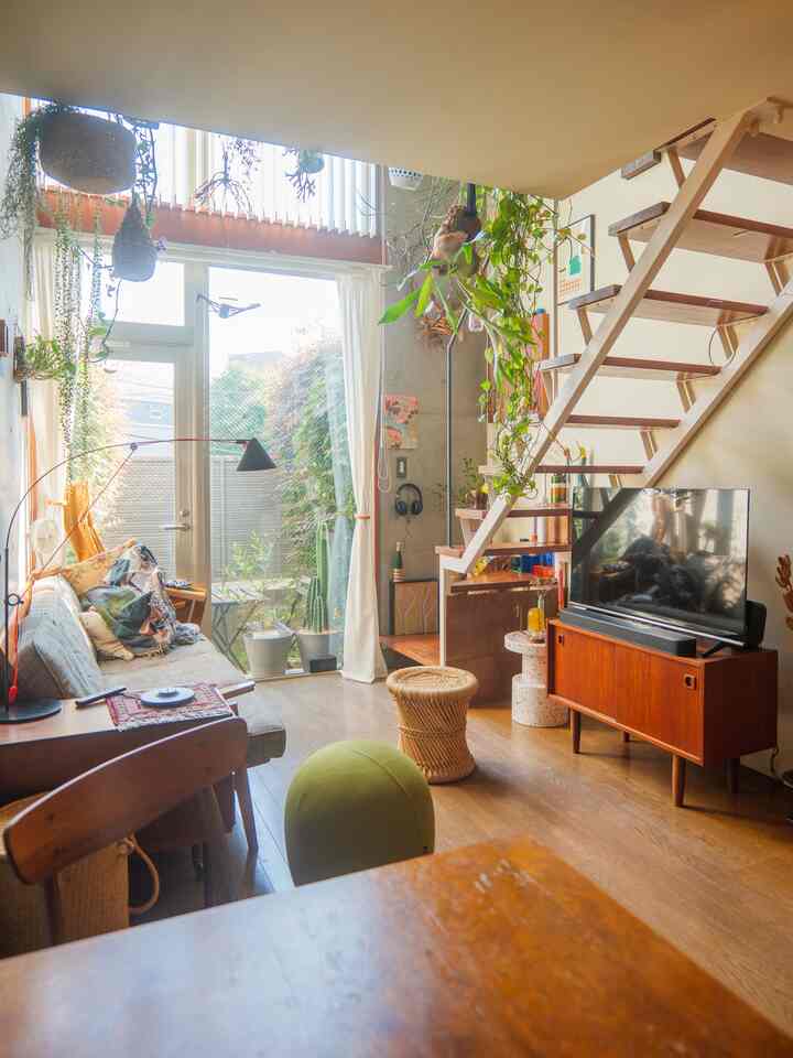 Natural-toned two-person living room with large windows and plants, creating a bright and cozy atmosphere