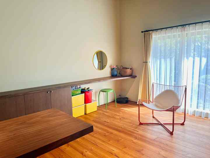 Natural-tone living room with yellow curtains and orange armchair, spacious and bright environment