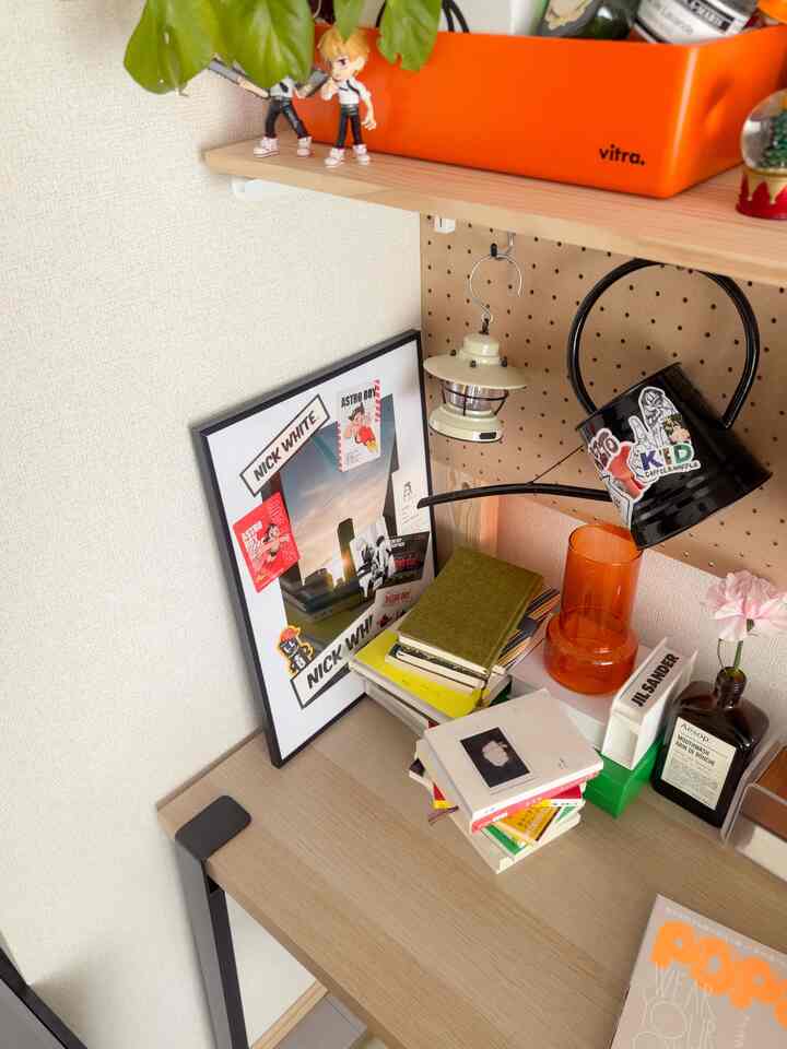 A natural-toned desk space featuring a poster and small decorative objects arranged in a cozy and aesthetic way