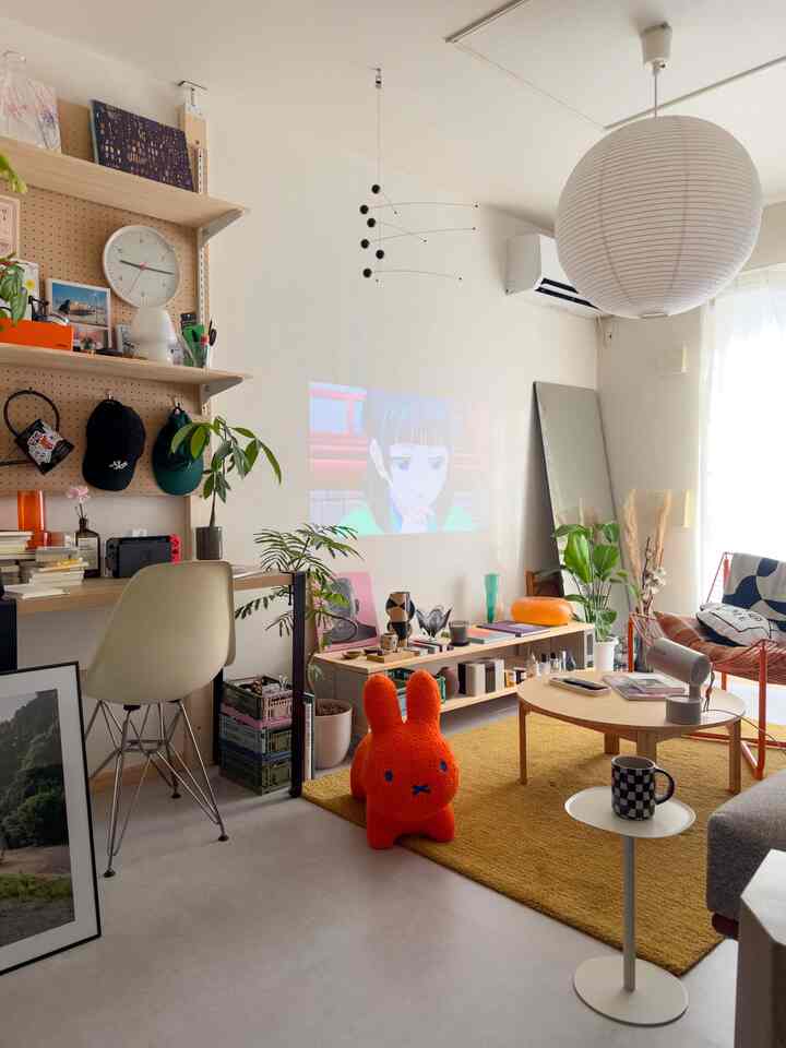 White and yellow toned living room featuring desk, rug, and plants with a modern natural vibe