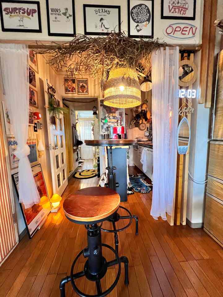 ナチュラルな木目調のキッチンとダイニング、ヴィンテージスタイルのカウンターテーブルと椅子が配置された雰囲気のある空間