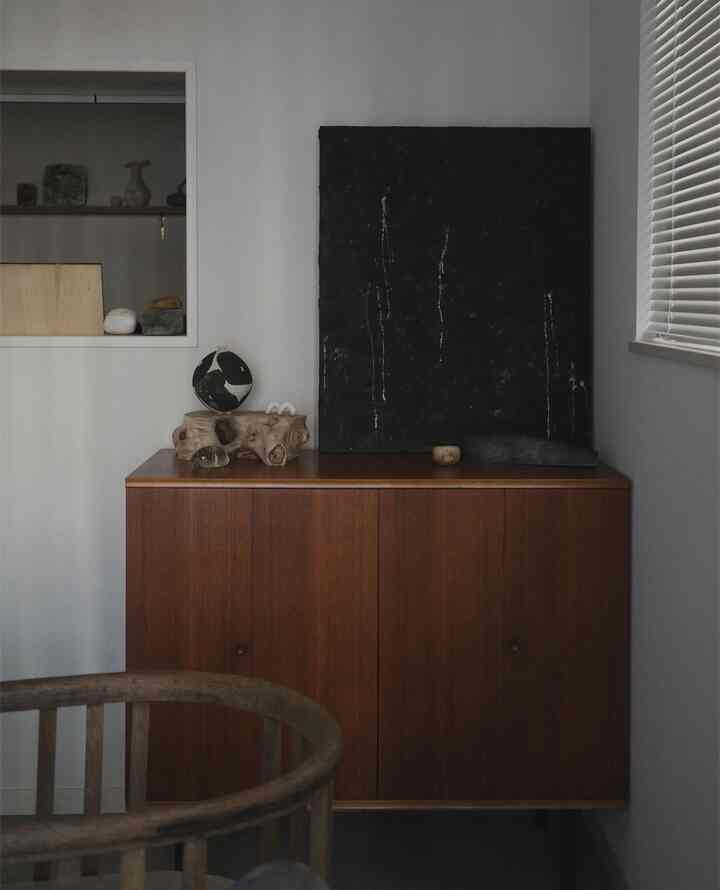 Gray walled dining room featuring a wood tone cabinet with simple decor and natural elements
