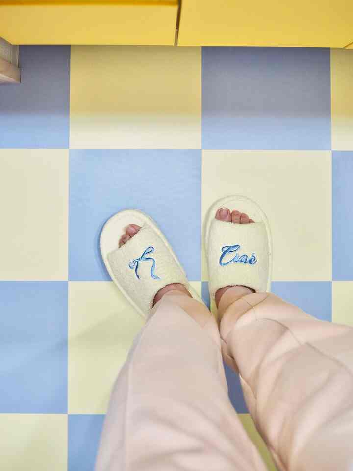 Pastel-toned bathroom floor with cream room slippers in a cozy setting