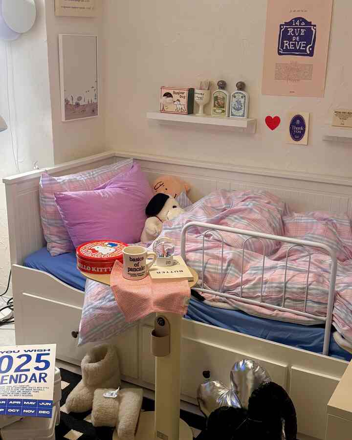 パステルカラーの枕とチェック柄の掛け布団が置かれた白いベッドのある居心地の良い子供部屋