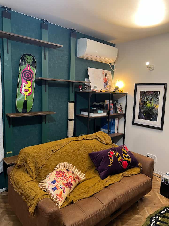 ナチュラルな色調のリビング、ブラウンのソファと木目調の棚が配置された雰囲気のあるインテリア