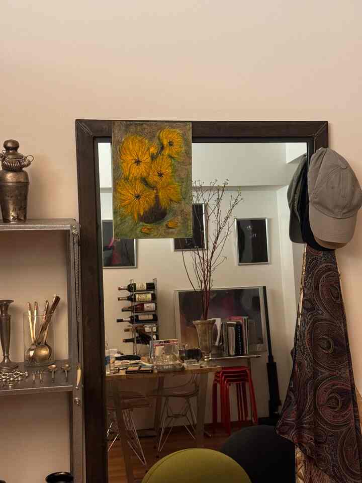 ブラウンの木目調床とインダストリアルな棚がある一人暮らし向け1LDK空間、大きな鏡とダイニングテーブルが配置されたコンパクトなインテリア