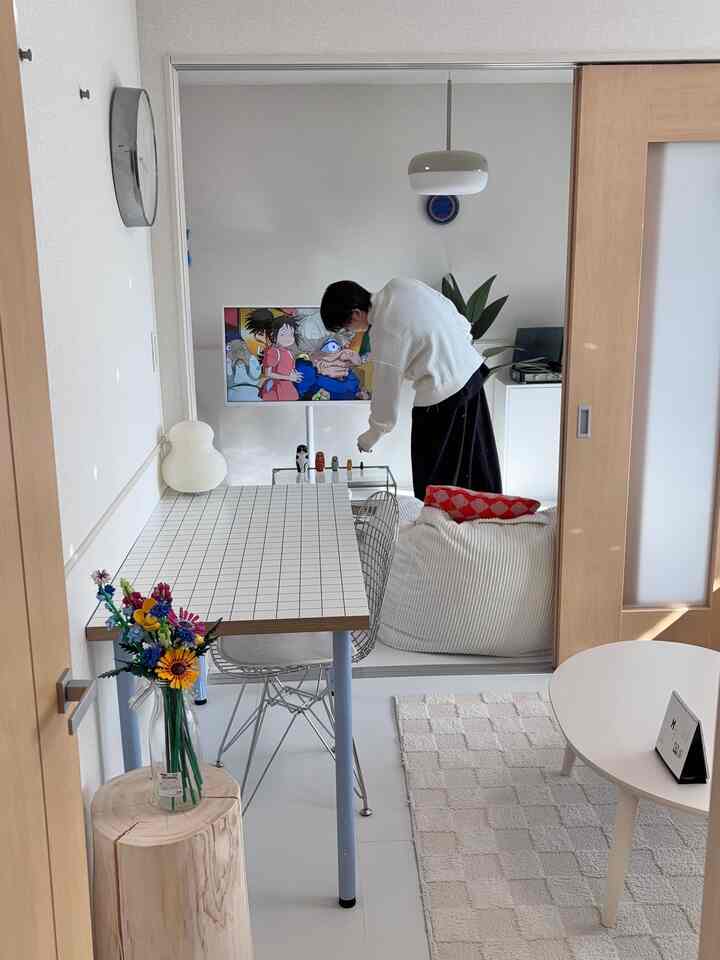 White-toned living room featuring a checkered table and a bean bag sofa with a simple, cozy atmosphere