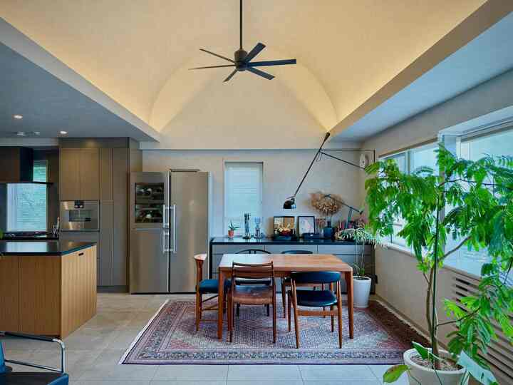 ナチュラルトーンのキッチンダイニング、広い窓と植物が配置された雰囲気のあるインテリア