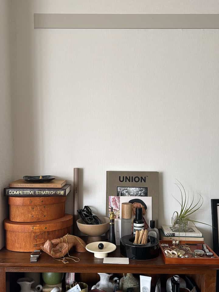 ブラウンの木目調家具と白い壁が調和するリビングのアクセサリーディスプレイのある自然な空間