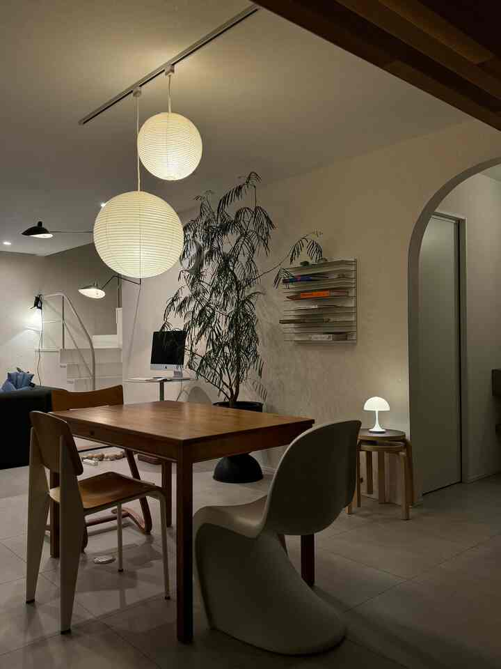 Natural wood tones and white pendant lights in a Nordic-style living and dining space