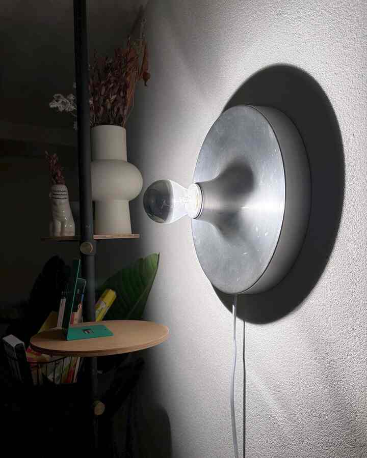 Natural-toned 8-tatami room featuring a silver wall sconce, dried flowers, and wooden shelf creating a cozy atmosphere