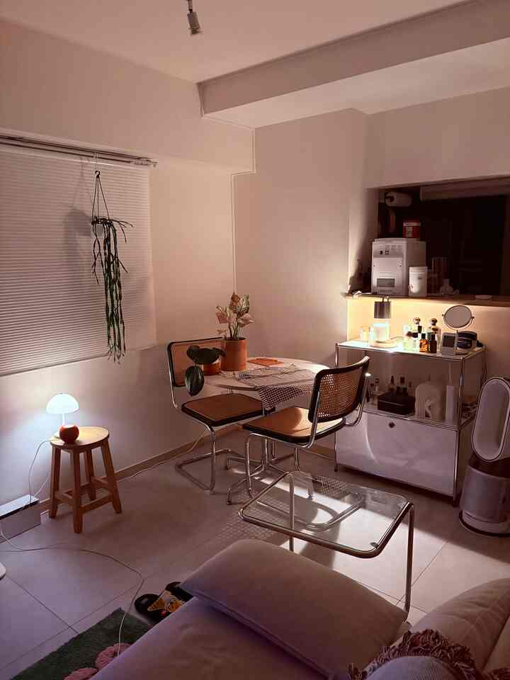 Cozy compact two-person dining space in soft beige and white tones featuring Mid-Century Modern chairs and a glass table