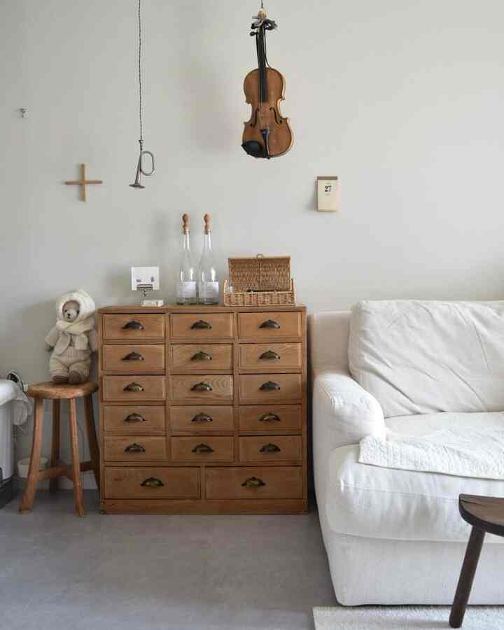 White and wood tone living room featuring a sofa and wooden sideboard with a natural and simple atmosphere