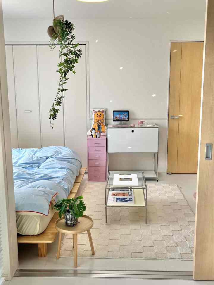 Modern natural bedroom and home office space featuring white walls and wood-toned furniture