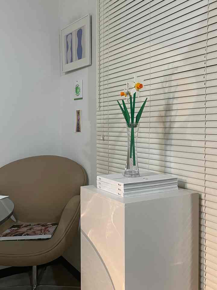 白とベージュの色調の一人暮らしリビング、SWANアームチェアとサイドテーブルが配置されたシンプルで清潔感のあるインテリア