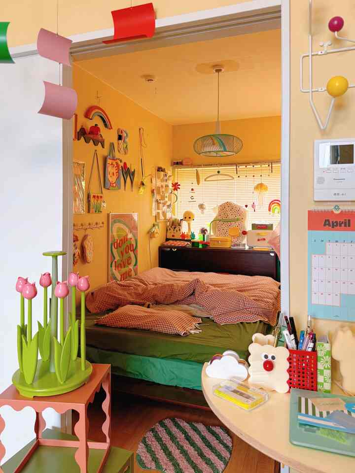 Cozy bedroom with yellow walls and green bedding, featuring vintage vibes and charming decorative items