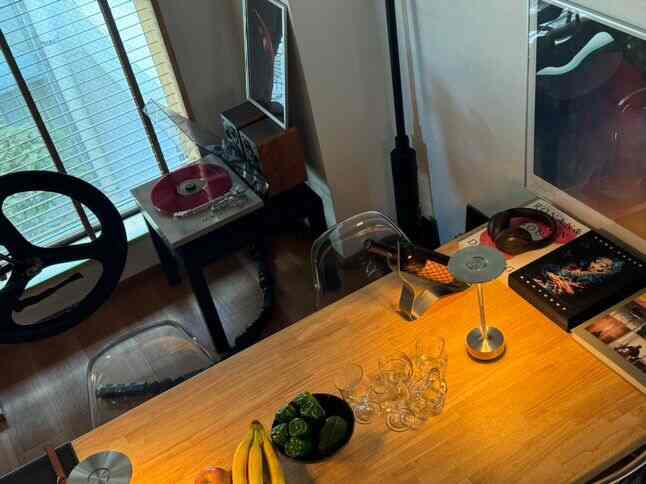 ウッドトーンと透明な椅子が配された一人暮らし向けの1LDK空間、ホームカフェ風のダイニングテーブルとアールデコ調の小物が印象的なインテリア