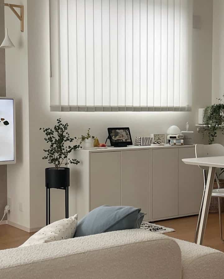 ホワイトとベージュの色調のリビング・ダイニングルーム、清潔感のある収納家具とダイニングテーブルが配置された明るいモダンな空間