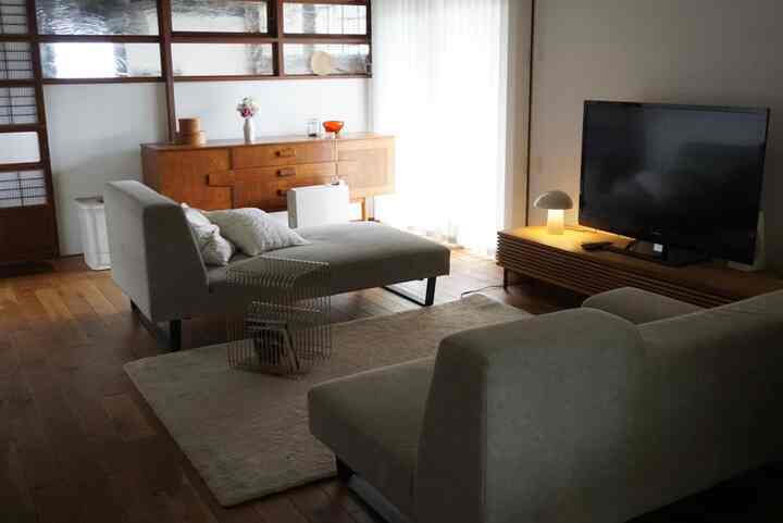 Warm living room with beige sofas and brown wooden vintage furniture arranged naturally