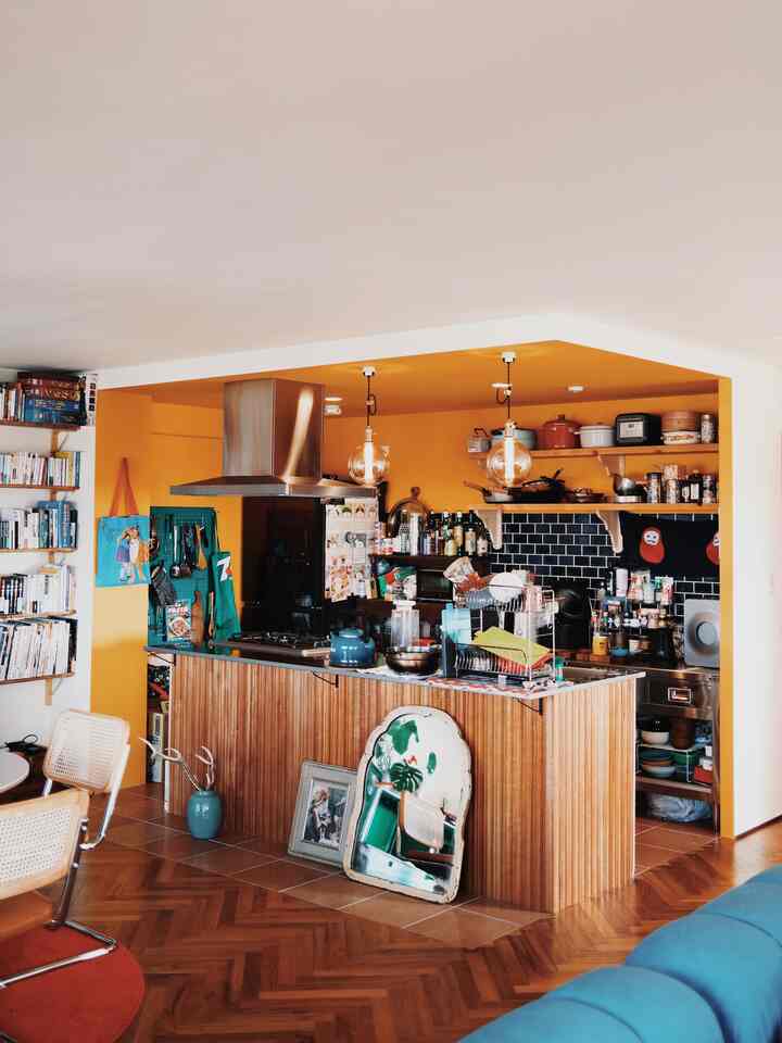Yellow-walled kitchen with wood-toned island in Mid-Century Modern style space