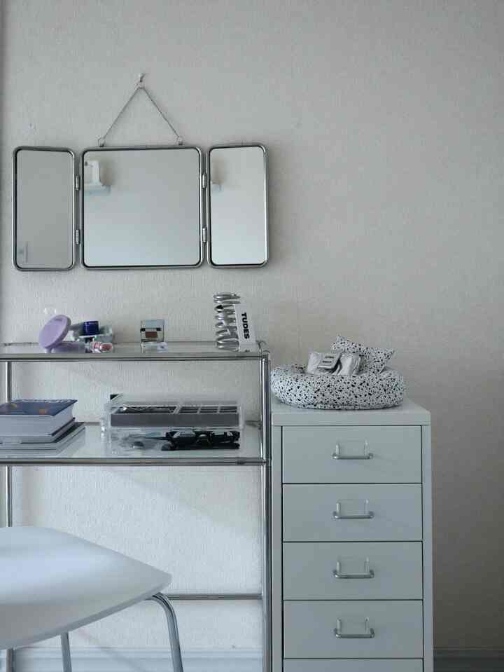 白とシルバーを基調としたシンプルなドレッサースペース、鏡と化粧台が配置され、清潔感のある雰囲気のインテリア