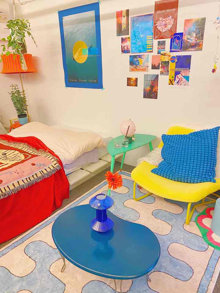 Bright yellow armchair with blue cushion and blue coffee table in a studio apartment, creating a warm and cozy vibe