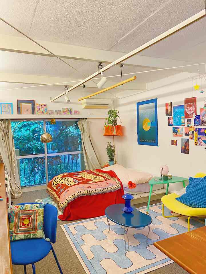 Bright pink, red, and blue tones in a studio bedroom featuring colorful furniture and vibrant cozy decor