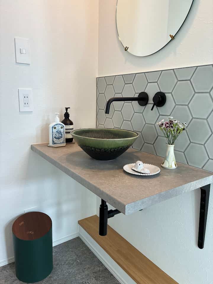 Mid-Century Modern restroom with green sink and gray hexagonal tile wall showcasing natural and sleek design