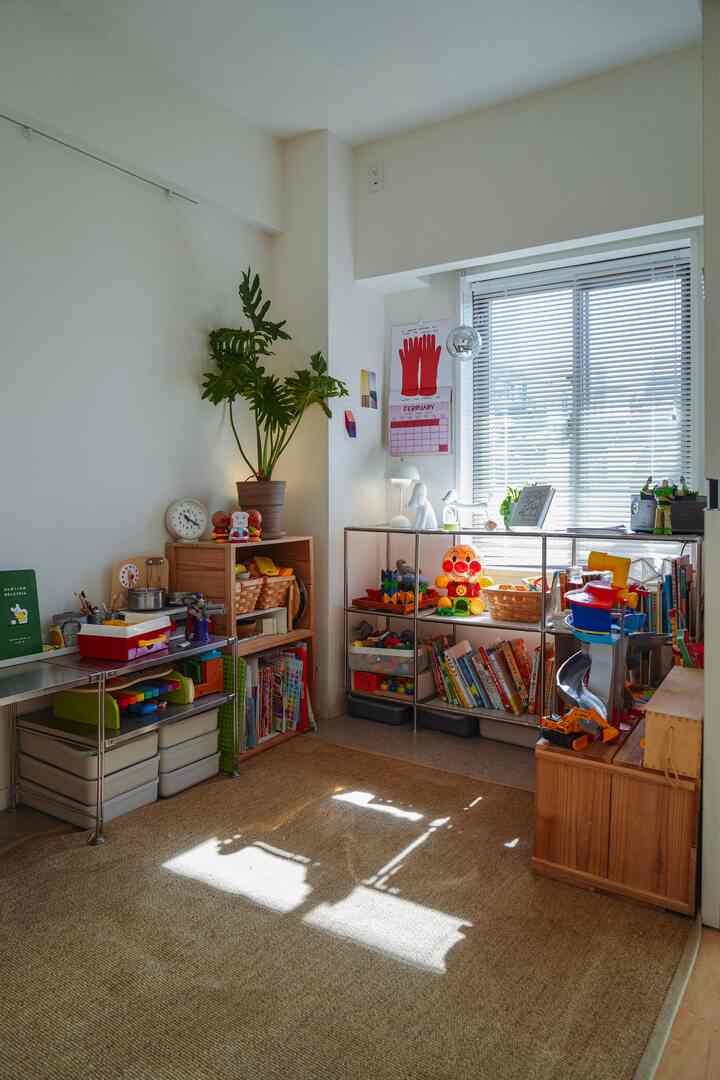 白い壁とナチュラルな木製棚が配置された子供部屋、おもちゃと本が整然と並ぶ明るく居心地の良い空間