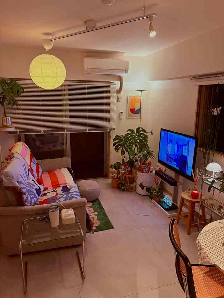 ナチュラルな色調のリビングルーム、多彩な植物が配置された印象的な空間