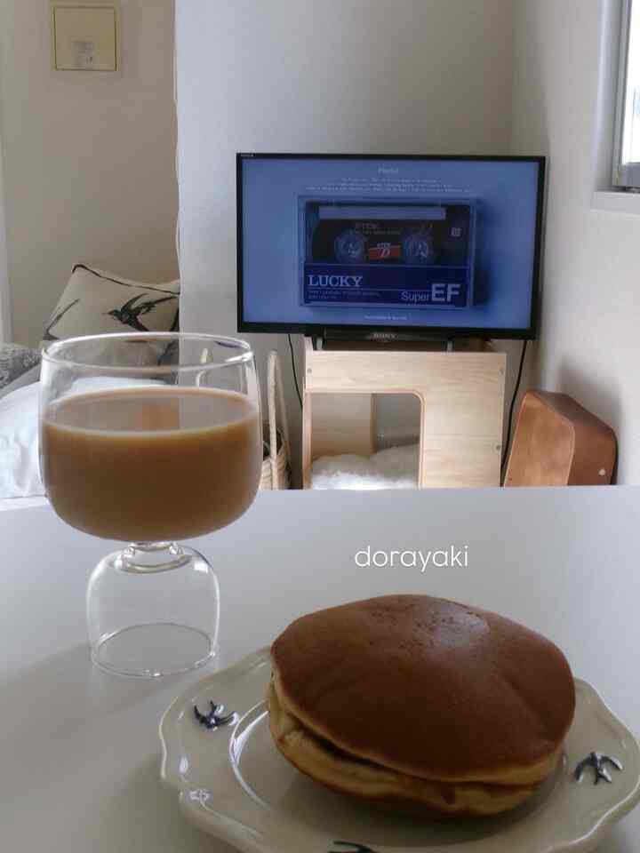 白と木目調のリビング、テーブル上にホームカフェの飲み物とどら焼き、キャットタワーが配置された落ち着いた空間