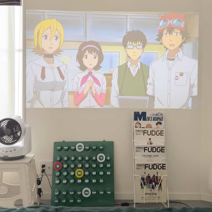 White and green toned living room featuring a projector screen, perpetual calendar, and magazine rack with clean atmosphere