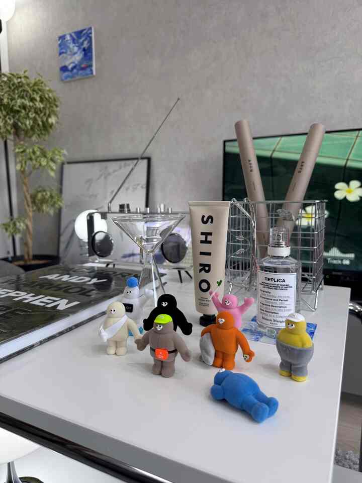 白を基調としたリビング、ミッドセンチュリーモダンスタイルのテーブルにキャラクターの装飾品と化粧品が配置された雰囲気のあるインテリア