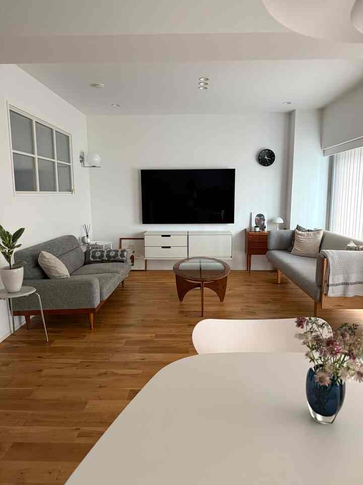 ナチュラルな木目調とグレーのソファが配置された北欧スタイルのリビングとダイニングの印象的な空間