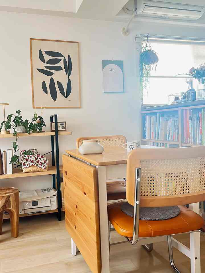 自然な木目調のダイニングテーブルと椅子が配置された、日当たりの良いコンパクトなリビングスペース