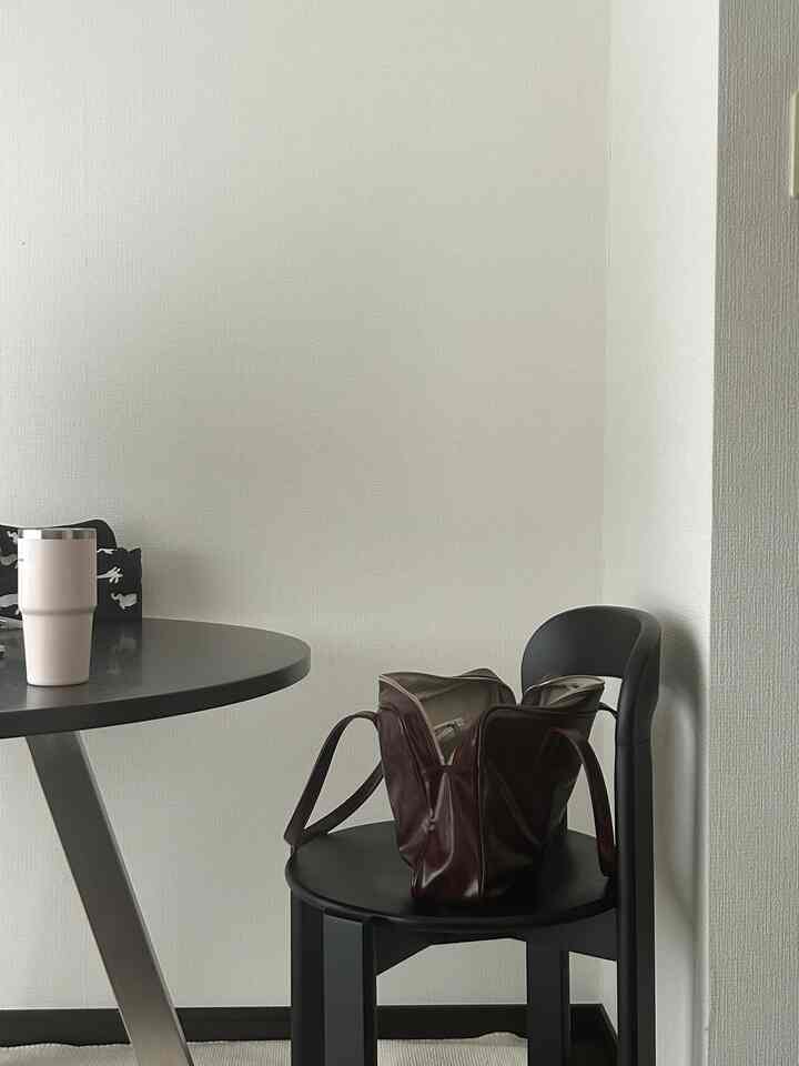 黒と白のトーンのダイニング、丸いダイニングテーブルと椅子が配置されたモダンな雰囲気の空間