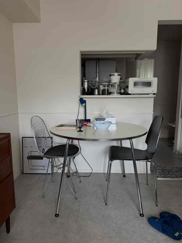 White-toned 1LDK dining room featuring round dining table with two dining chairs in a modern setting