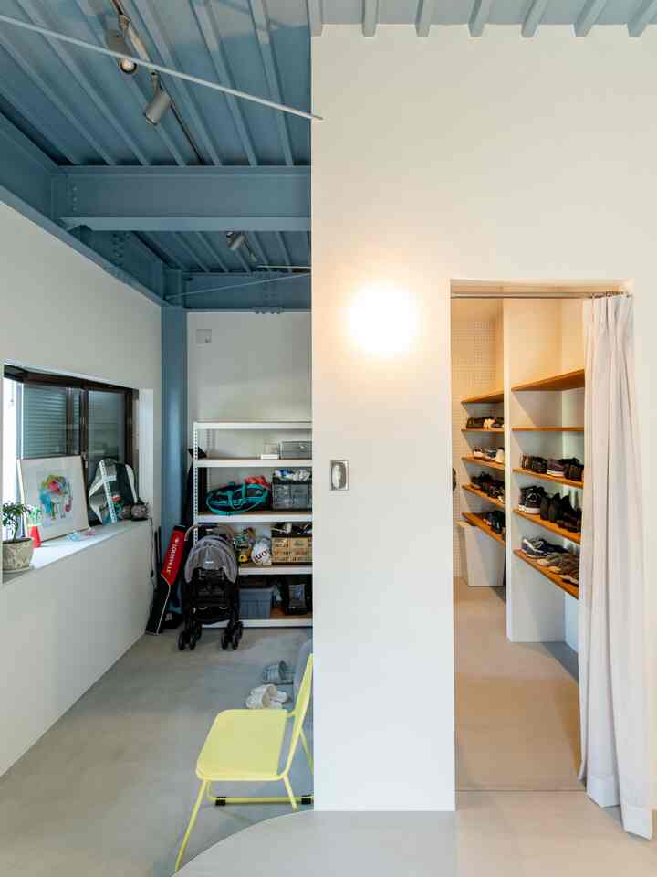 Entrance space with white walls and blue ceiling, featuring storage shelves and shoe cabinets in a practical layout