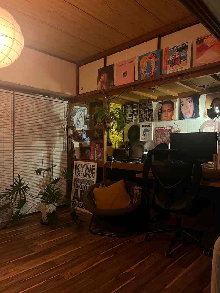 ダークブラウンの木目調ホームオフィス、机と椅子、展示されたポスターが配置された雰囲気のあるインテリア