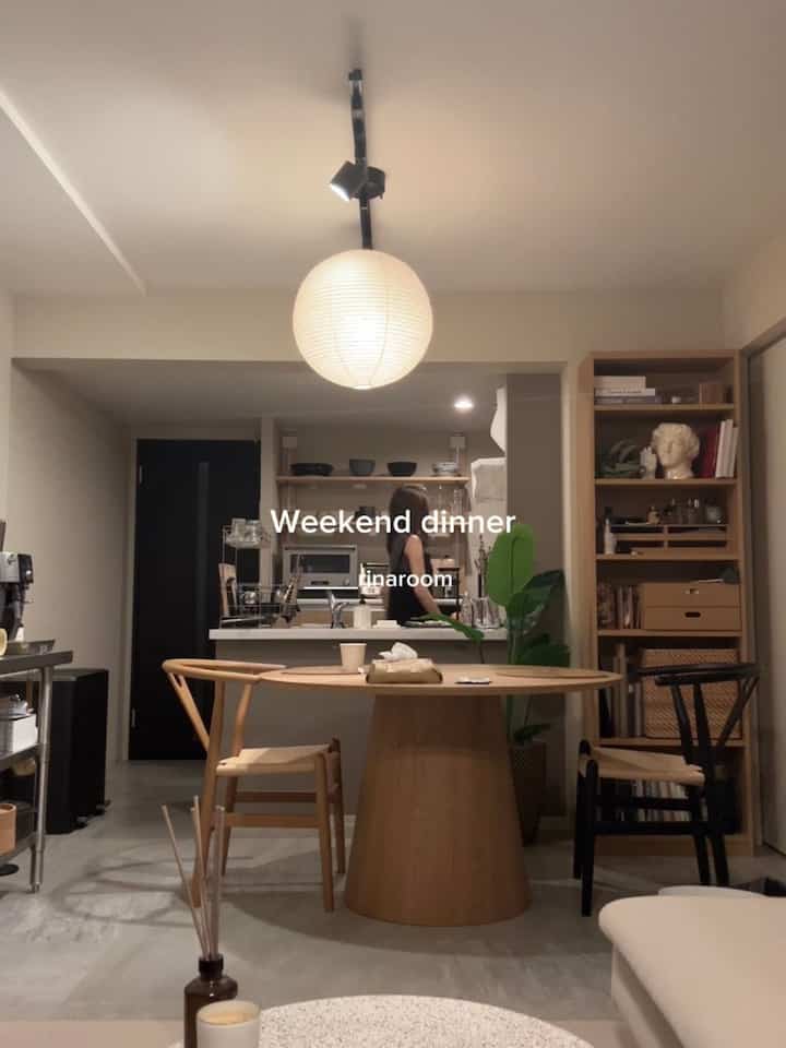A natural wood tone dining room featuring a round dining table and chairs in a clean, minimal setting