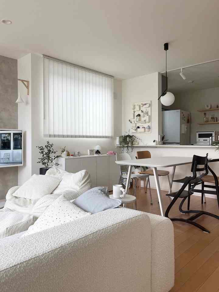 白とウッドトーンが調和するリビングダイニング、シンプルでモダンな家具が配置された明るい印象的な空間