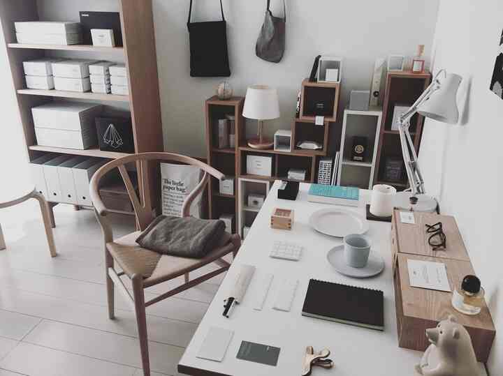 白と茶色のナチュラルトーンが特徴のシンプルでミニマルなホームオフィス、机と椅子が配置された雰囲気のあるインテリア