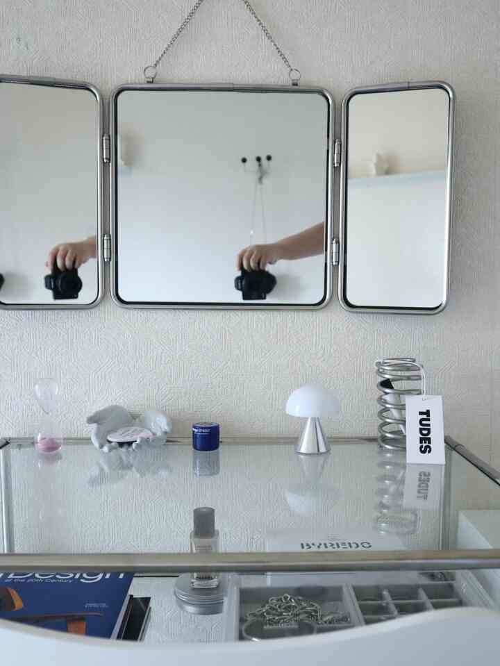A white and stainless steel vanity space featuring minimal accessories with a clean atmosphere