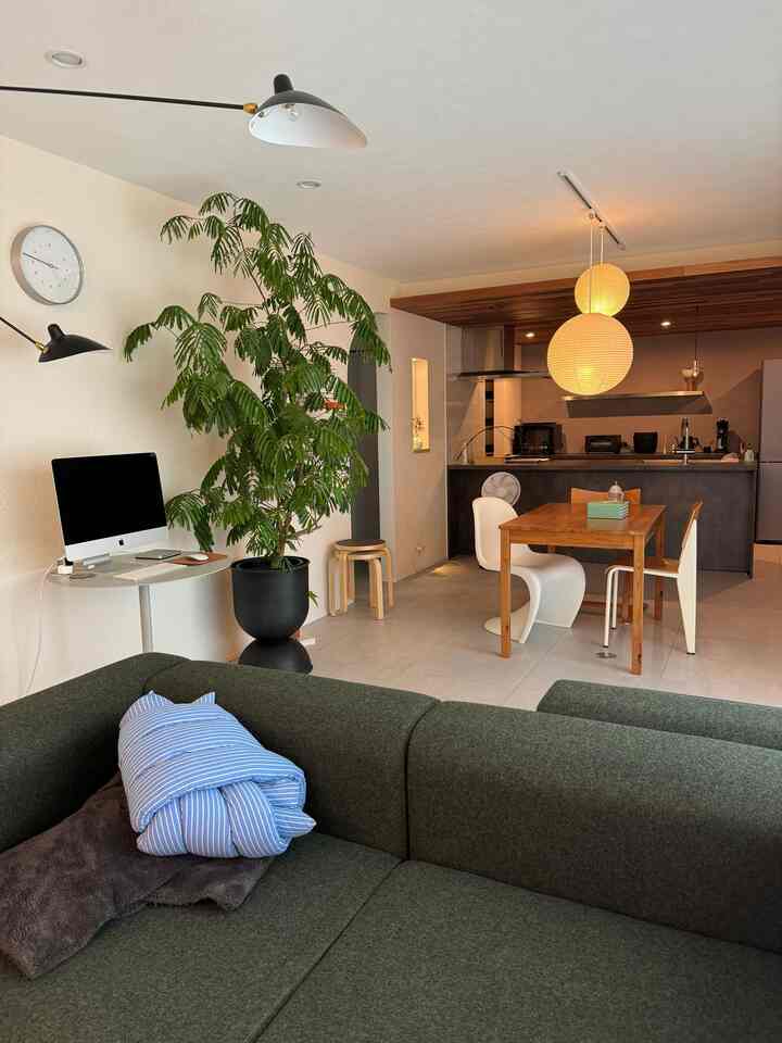 白い壁と木目調の家具が配置された北欧ミッドセンチュリーモダンの二人暮らし向けリビング・ダイニング空間