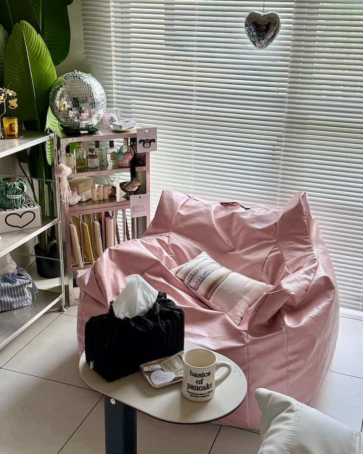 White-toned living room featuring a pink bean bag and silver shelving, creating a cozy and modern atmosphere