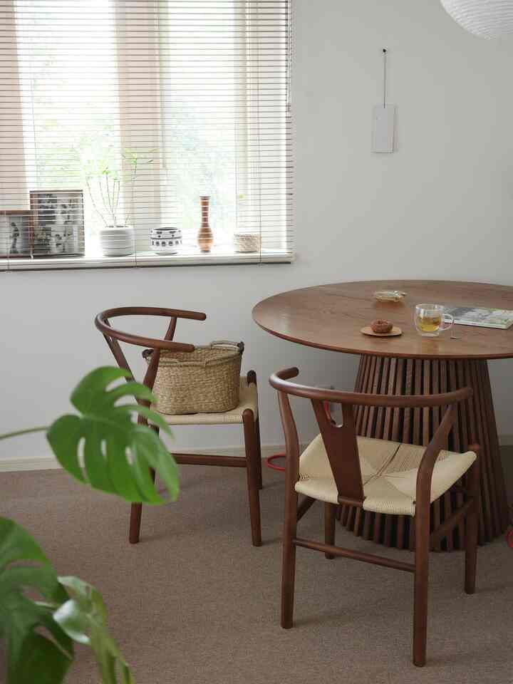 ブラウンの木製ダイニングテーブルと椅子が配置された白い壁の和モダンなダイニング、柔らかく自然な雰囲気のあるインテリア