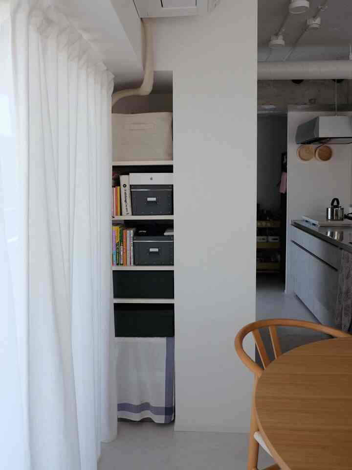 White and wood tone dining room and kitchen space featuring neat natural storage ideas with a clean modern ambiance