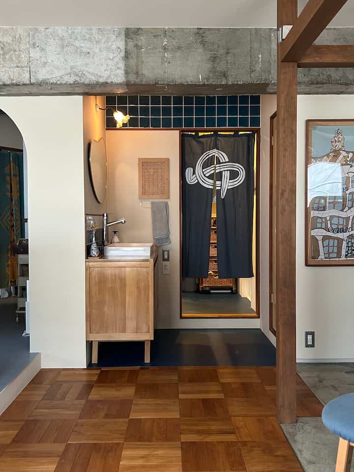 Natural wood tone bathroom with a dark blue sliding door curtain in a long and narrow space
