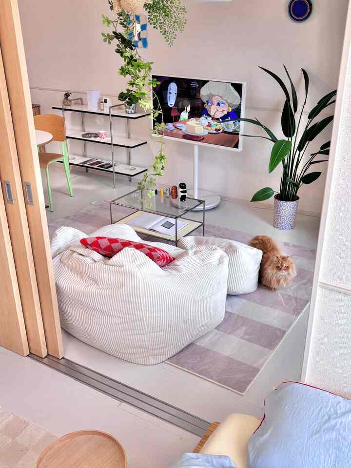 ホワイトとナチュラルトーンのリビング、ビーズクッションとテレビ台、猫がいる印象的で居心地の良い空間