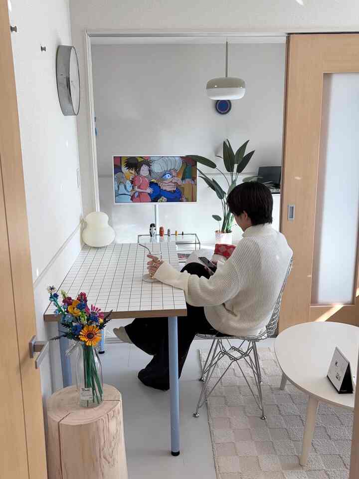 白とナチュラルカラーのリビング、タイルのダイニングテーブルとテレビスタンドが配置された清潔感のあるおうちカフェのインテリア